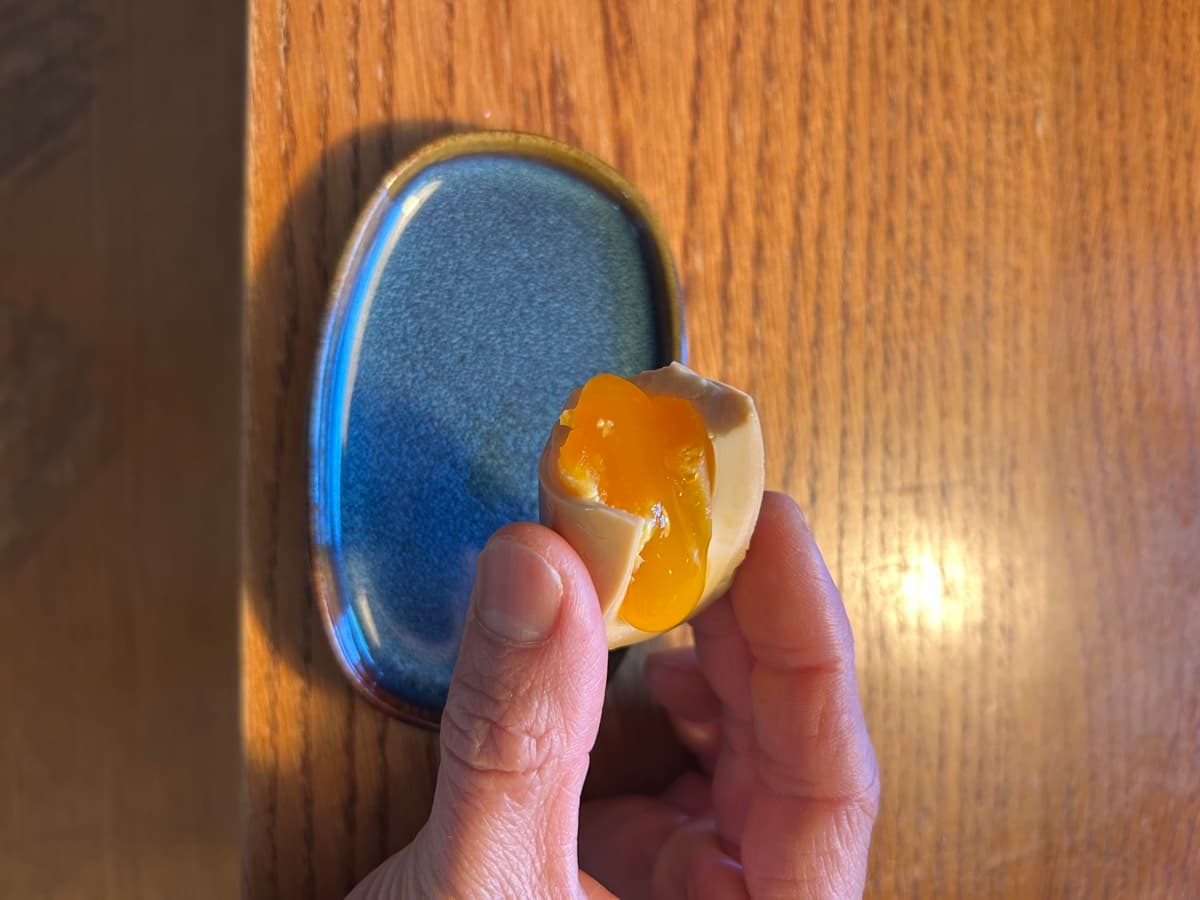 Sliced ajitama ramen egg on a blue ceramic plate